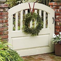 a white gate with a wreath hanging on it