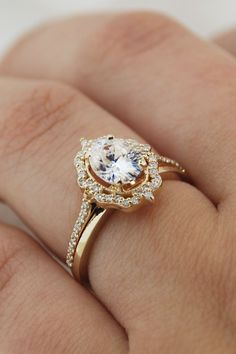 a woman's hand with a gold ring and diamond set in the middle, on top of her finger