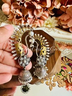 Looking for a unique STATEMENT set of jhumka style earrings with an ear cuff style  and doesn't hurt your ear lobes, look no further! This lightweight dual tone brass-based textured silver tone finish jhumka style earrings has a very contemporary style with carving on the jhumka itself with kundan stones and  pearl embellishments at the bottom of earrings as well. The combination of textured base with a dual tone brass-based metal finish will surely captivate a jaw-drop attention as soon as you enter any event.  It's the right balance you need to make a statement but not over the top.   This design comes in 5 variations:  1. White/Pearl 2. All clear  3. All green  4. Green/red 5. Turquoise    Highlights of the piece: ** Dangled full jhumka style earrings with height: 3.25 inch ** Pushback Elegant White Earrings For Navratri, Handmade Festive Dangle Pearl Earrings, Festive Handmade Dangle Pearl Earrings, Festive Unique Latkan Earrings, Traditional White Danglers With Intricate Design, White Chandbali Earrings For Navratri, White Jhumkas With Intricate Design For Celebration, White Intricate Design Jhumkas For Celebration, Handmade White Earrings For Festive Occasions