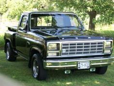 a black pickup truck parked in the grass