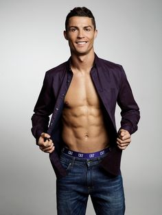 a shirtless man is posing with his hands on his hips and wearing blue jeans