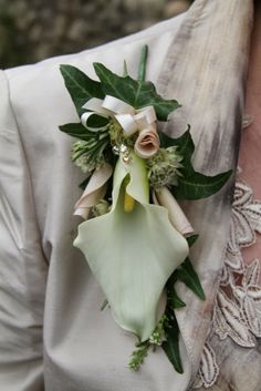 a close up of a person wearing a boutonniere with flowers on it