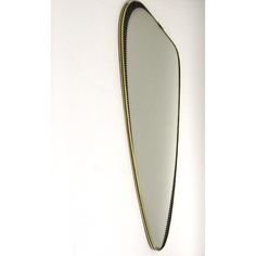 a mirror that is on the wall with a black border and gold trim around it