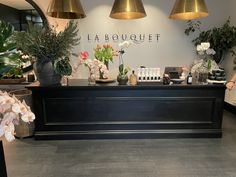 the front desk of a flower shop with flowers on display