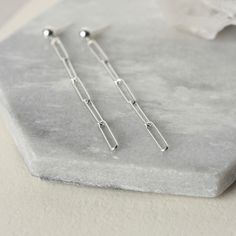 These long dangle earrings feature trendy sterling silver paper clip chain with a sleek modern look. The rectangle links measure 12mm long and about 3mm wide and the chain has a nice bright polish. It is made of Hill Tribe Silver which has a higher silver content than sterling (97% to 92.5%) and features a beautiful luster. The chain is paired with 4mm sterling silver posts for a minimalist design that goes with everything. The earrings come in two lengths - the shorter length is about 1.5 inche Delicate Sterling Silver Linear Earrings With Chain, Minimalist Nickel-free Dangle Linear Earrings, Unique Nickel-free Dangle Linear Earrings, Silver Box Chain Dangle Linear Earrings, Modern Sterling Silver Tarnish-resistant Linear Earrings, Sterling Silver Star Earrings, Big Statement Earrings, Silver Chandelier Earrings, Silver Paper