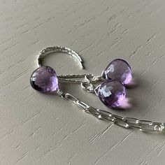 Simply wrapped in sterling silver, a single 10mm pink amethyst heart briolette is suspended on a popular paperclip chain.   Using all sterling silver, this piece has peridot and kyanite accents added between the links. I envision this necklace higher on the neck, making it a simple yet sparkling piece for your jewelry wardrobe.  Chain length is chosen at checkout. The matching earrings have gorgeous gems on elongated earwires.  If you would like something simpler, these can be exchanged at no co Teardrop Amethyst Jewelry With Faceted Detail, Teardrop Faceted Amethyst Jewelry, Silver Faceted Briolette Gemstones, Faceted Teardrop Amethyst Jewelry, Faceted Briolette Silver Gemstones, Everyday Amethyst Dangle Jewelry, Minimalist Purple Drop Earrings, Sterling Silver Teardrop Birthstone Gemstones, Sterling Silver Briolette Earrings