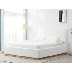 a white bed sitting in a bedroom next to a window