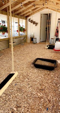 the inside of a building with wood chips on the floor