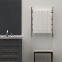 a white towel hanging on the wall next to a black dresser and chair in a bathroom