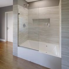 a bathroom with a glass shower door and wood flooring on the side of the room