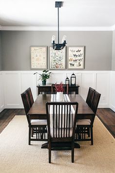 a dinning room table with chairs and pictures on the wall