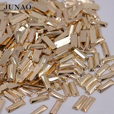 gold plated metal beads are scattered on a white surface