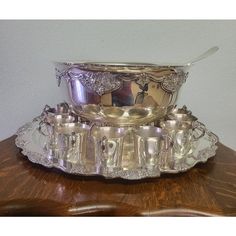 a silver plate with cups and saucers on it