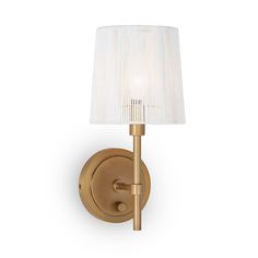 a wall light with a white shade on the side and a gold finish to it