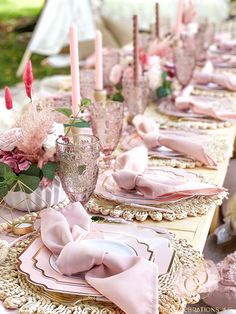 the table is set with pink napkins and place settings for an elegant dinner party