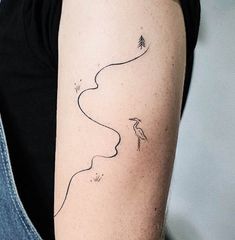 a woman's arm with a line drawing of a bird and trees on it