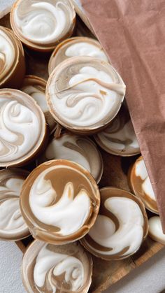 some cupcakes with white icing on top of them and a brown paper bag