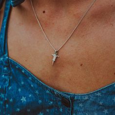 a woman wearing a necklace with a small star on it