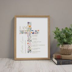 a cross with flowers and the words i am on it next to a potted plant