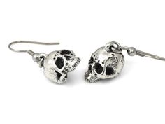 We wanted these skulls to be a little more realistic and spooky than our other human skull earrings and we think that we pulled it off nicely! The design was carved by hand in wax and then molded and cast in metal.The skull charms are cast in Lead Free Pewter and weighs a bit under 5 grams each. They are about 13 mm long (just over half an inch) and dangle from Stainless Steel earring hooks. They are oxidized to fill in the details and then polished.For more of our skull earrings please look her Gothic Skull Earrings For Halloween, Punk Skull Print Earrings Gift, Punk Skull Print Earrings For Gift, Punk Style Skull Print Earrings As Gift, Halloween Skull Print Skull Earrings, Nickel-free Skull Earrings In Punk Style, Gothic Skull Print Earrings As Gift, Gothic Skull Print Earrings For Gift, Silver Skull Earrings With Skull Print