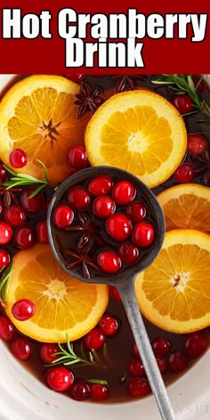 hot cranberry drink in a white bowl with oranges and rosemary