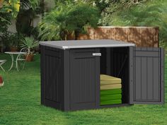 an outdoor storage shed with its doors open on the grass near a table and chairs