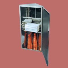 an open metal cabinet with towels and orange cups