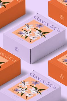 four boxes with flowers on them sitting side by side in the middle of an orange and purple background