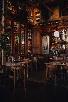 an old fashioned restaurant with wooden tables and chairs, bookshelves in the background