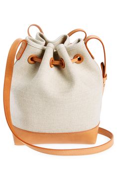 Cool Italian canvas and luxe leather shape a petite bucket bag with sturdy structure and a drawstring-cinched top. Drawstring closure Adjustable crossbody strap Structured silhouette with flat base for stability Textile with leather trim Made in Italy Designer Handbags Cinched Top, Crossbody Bags For Travel, Travel Bags For Women, Designer Crossbody, Mansur Gavriel, Leather Bucket Bag, Leather Bucket, Handbag Straps, Mini Canvas