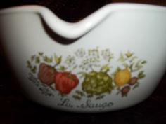 a white bowl with fruit painted on it