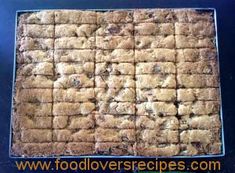 a square cookie with chocolate chips on it sitting on top of a blue tablecloth