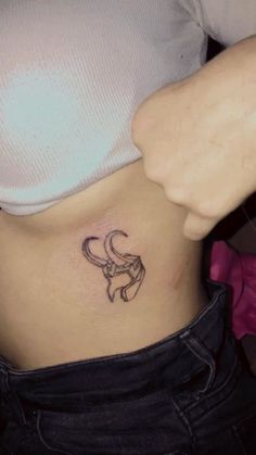 a woman's stomach with a small tattoo on the side of her belly,