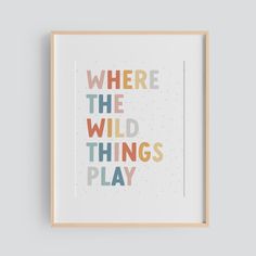 a framed poster with the words where the wild things play in multicolored letters