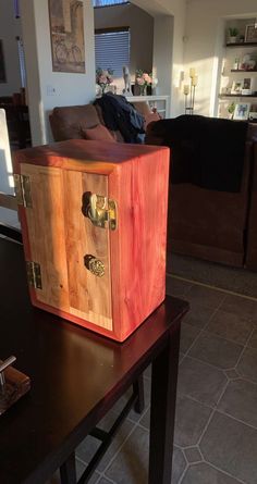 a wooden box sitting on top of a table in a living room next to a couch