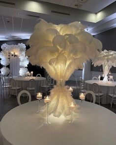 the centerpiece is made out of white feathers and lit candles