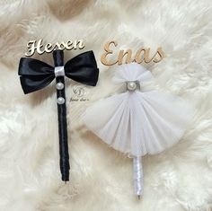 there is a small white dress and a black bow on the top of a pen