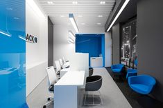 an office with blue chairs and white desks