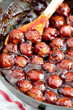 a skillet filled with meatballs and sauce on top of a red checkered table cloth