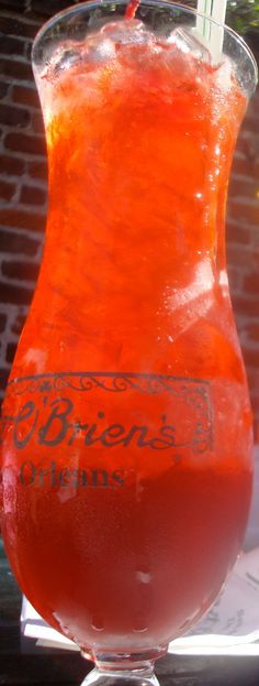 an orange drink in a tall glass on a table