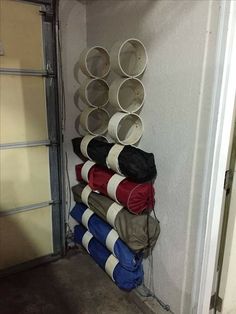 there are many cups and pans stacked on the wall next to an open garage door