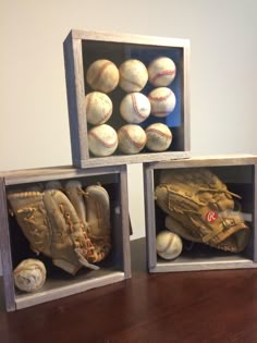 three wooden boxes with baseballs and mitts in them