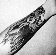 a black and white photo of a man's arm with a lion tattoo on it