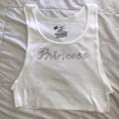 White tank top with "Princess" bedazzled in silver rhinestones! Tank Top Design Ideas, Bedazzled Clothes, Tiny Shirts, Bedazzled Top, Rhinestone Tank Top, Y2k Shirts, Rhinestone Outfit, Rhinestone Top, 2000s Fashion Outfits