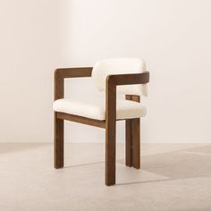 a wooden chair with a white upholstered seat and back rest, in front of a wall