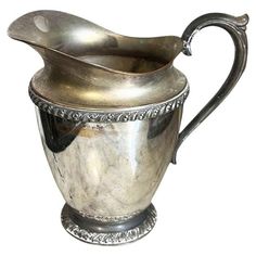 a silver pitcher with a spoon in it