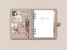 an open planner book with photos and flowers on the pages, in front of a beige background