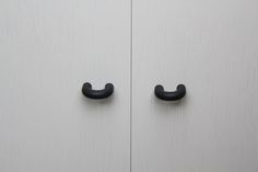 two black handles are on the white cupboards