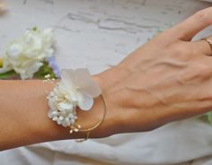 a close up of a person's arm wearing a bracelet with flowers on it