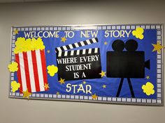 a welcome to new story banner hanging on the wall with popcorn and movie claps